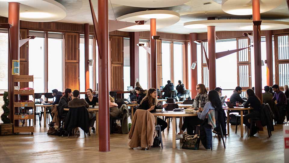 A photograph of students sat chatting in The Dennning